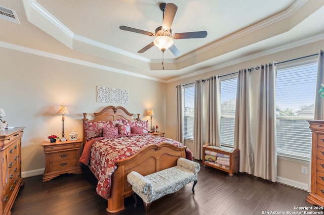 bedroom with dark wood-type flooring, multiple windows, a raised ceiling, and visible vents