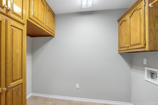 clothes washing area featuring hookup for a washing machine, cabinet space, and baseboards