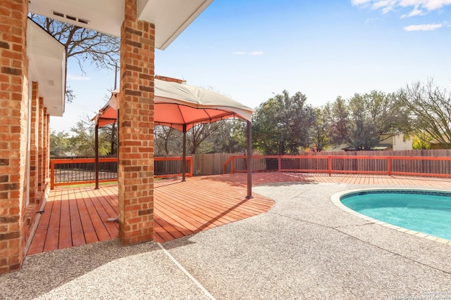 view of pool featuring a fenced backyard, a deck, a fenced in pool, and a gazebo