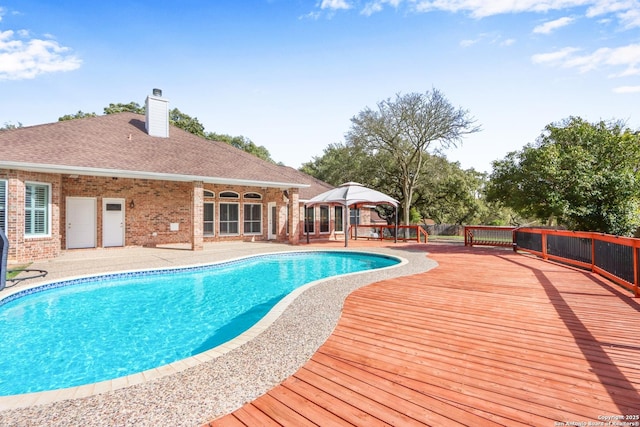 view of swimming pool featuring a fenced in pool, a patio area, and a deck