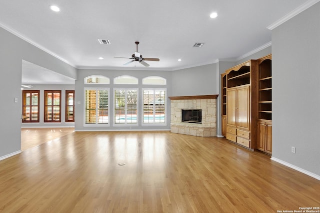 unfurnished living room with visible vents, ceiling fan, crown molding, light wood-type flooring, and a fireplace