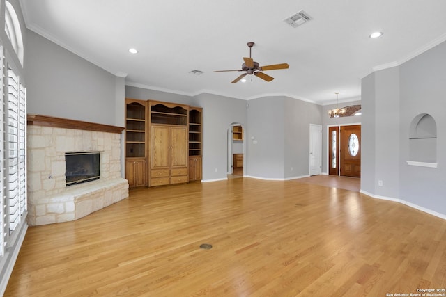 unfurnished living room featuring visible vents, arched walkways, baseboards, light wood-style flooring, and a fireplace