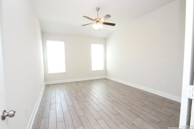 empty room featuring wood finished floors, a ceiling fan, and baseboards