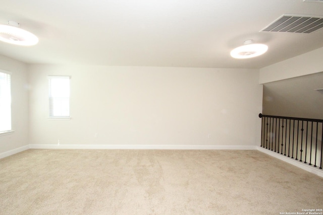 unfurnished room featuring light carpet, visible vents, and baseboards