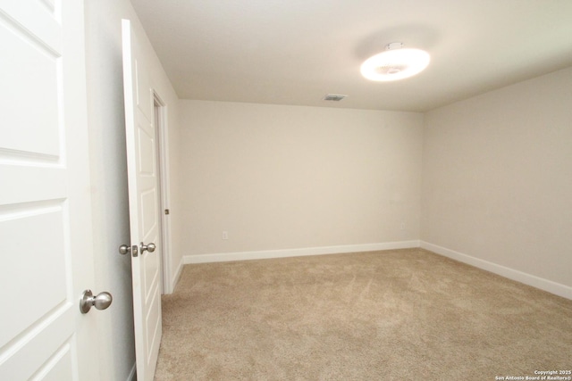 empty room featuring baseboards, visible vents, and light colored carpet