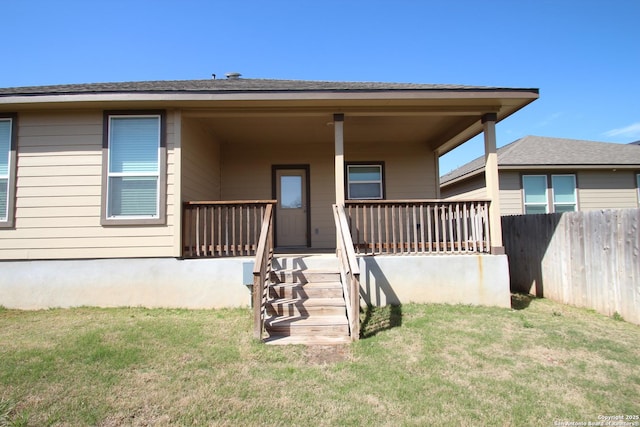 exterior space with fence, a porch, and a lawn