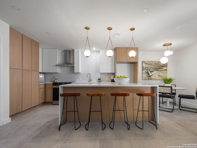 kitchen with wall chimney range hood, modern cabinets, stainless steel electric stove, and a center island