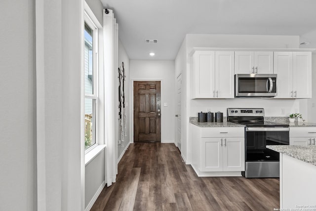 kitchen with plenty of natural light, visible vents, appliances with stainless steel finishes, and dark wood-type flooring