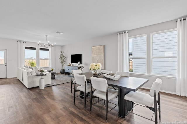 dining room with dark wood-style floors, baseboards, visible vents, and a chandelier