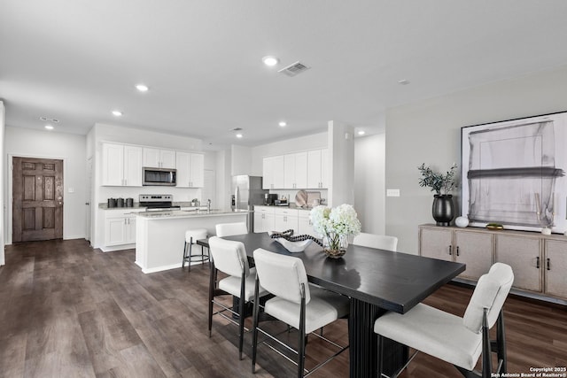 dining area with baseboards, visible vents, dark wood-type flooring, and recessed lighting