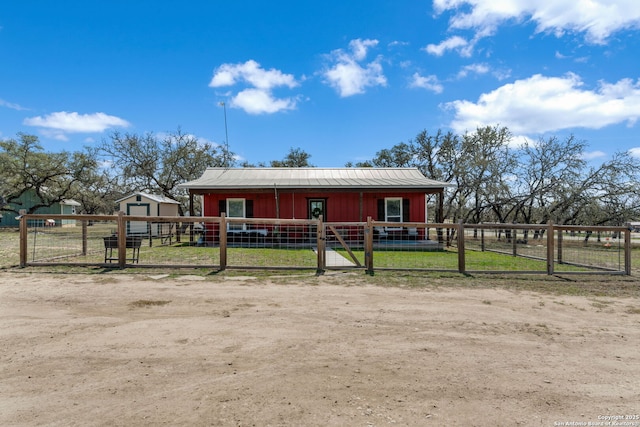 view of front of property featuring an outbuilding, metal roof, board and batten siding, and an exterior structure