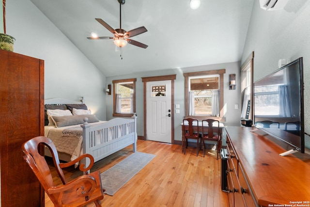 bedroom with high vaulted ceiling, a wall mounted AC, light wood-style flooring, and a ceiling fan