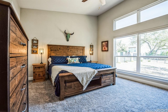 bedroom featuring ceiling fan, multiple windows, carpet flooring, and baseboards