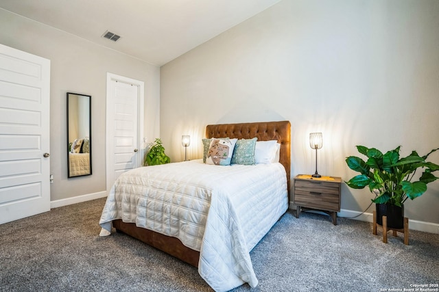 carpeted bedroom with visible vents, vaulted ceiling, and baseboards