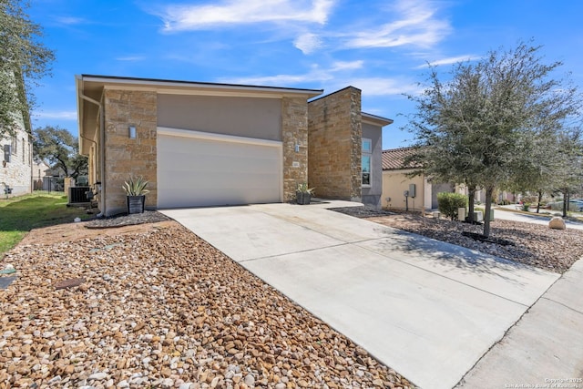 view of front of property with a garage, cooling unit, stone siding, and concrete driveway