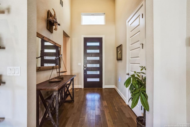 foyer entrance with dark wood-style floors, visible vents, and baseboards