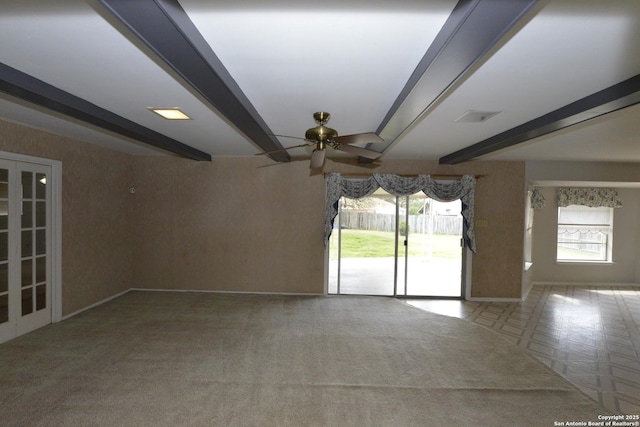 spare room with carpet, a ceiling fan, beam ceiling, and french doors