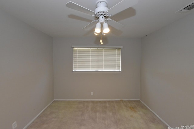 spare room featuring visible vents, ceiling fan, light carpet, and baseboards