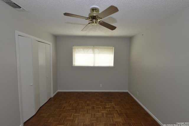 unfurnished bedroom with baseboards, a textured ceiling, visible vents, and a closet