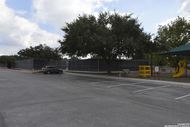 uncovered parking lot with playground community and fence