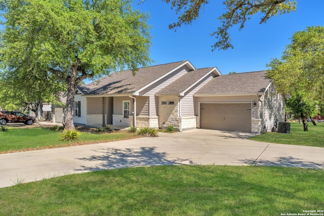 view of front of house with a garage, central AC, driveway, and a front lawn