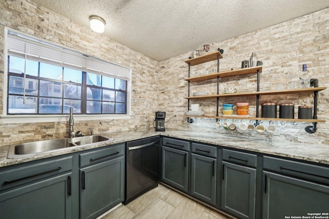 kitchen featuring a textured ceiling, dishwashing machine, a sink, light stone countertops, and open shelves