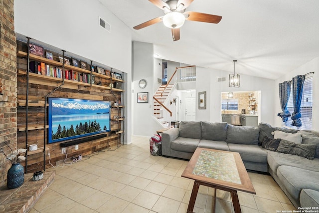 living area with lofted ceiling, stairway, visible vents, and tile patterned floors