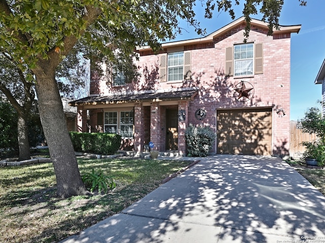 view of front of house with a front yard, concrete driveway, brick siding, and an attached garage