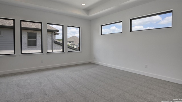 carpeted empty room featuring baseboards, a tray ceiling, and recessed lighting