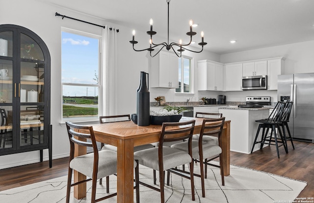 dining area featuring a chandelier, wood finished floors, and a healthy amount of sunlight