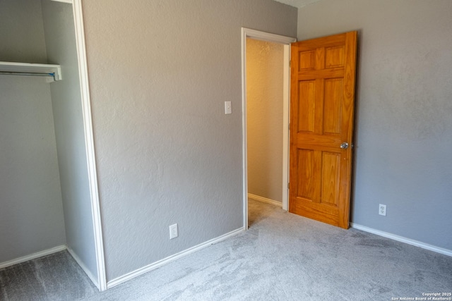 unfurnished bedroom featuring a closet, carpet, and baseboards