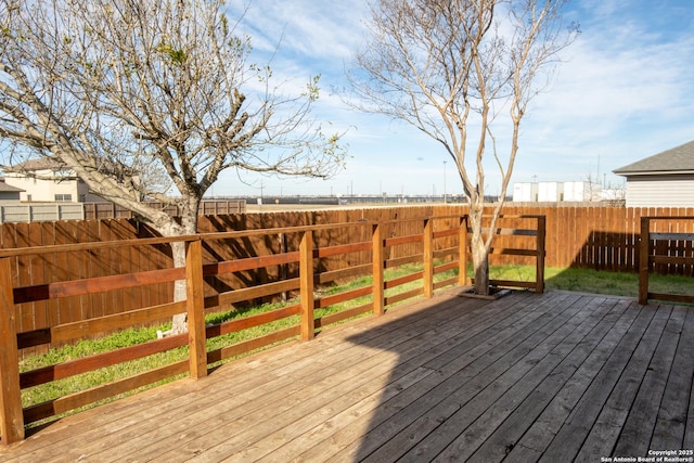 wooden terrace with a fenced backyard