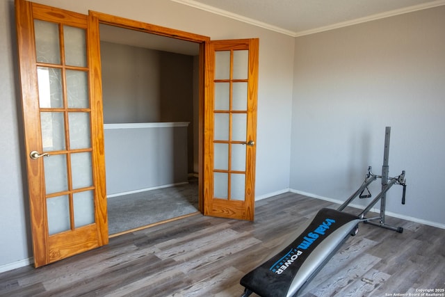 workout area featuring baseboards, ornamental molding, and wood finished floors