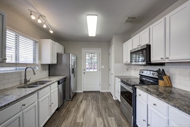 kitchen with dark wood-style floors, appliances with stainless steel finishes, a sink, and white cabinetry