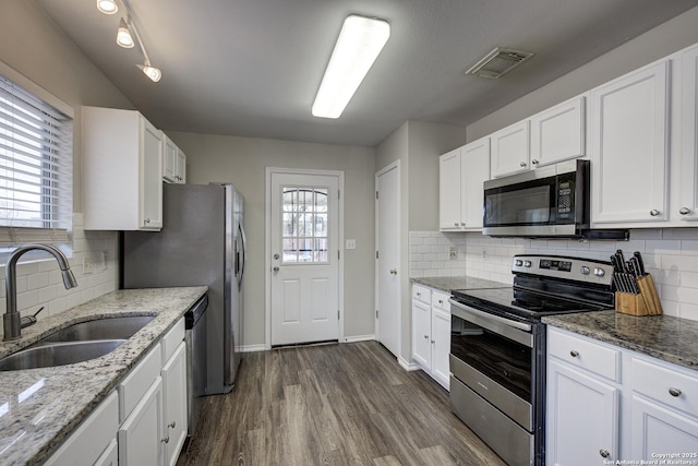 kitchen featuring stainless steel appliances, visible vents, dark wood-type flooring, white cabinets, and a sink