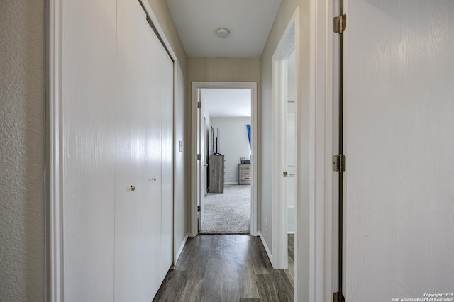 hall with dark wood-style flooring and baseboards