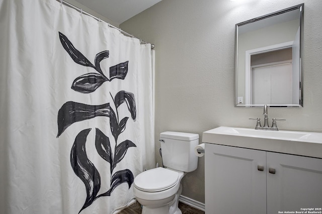 full bathroom featuring a textured wall, toilet, vanity, a shower with curtain, and baseboards