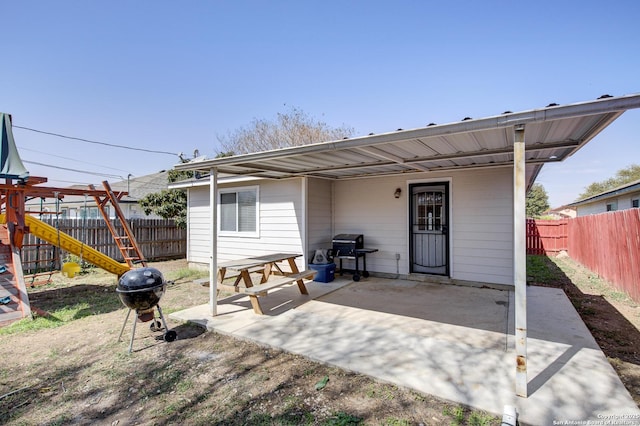 view of patio / terrace featuring a grill, a fenced backyard, and a playground