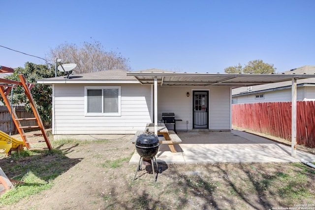 back of property with fence and a patio