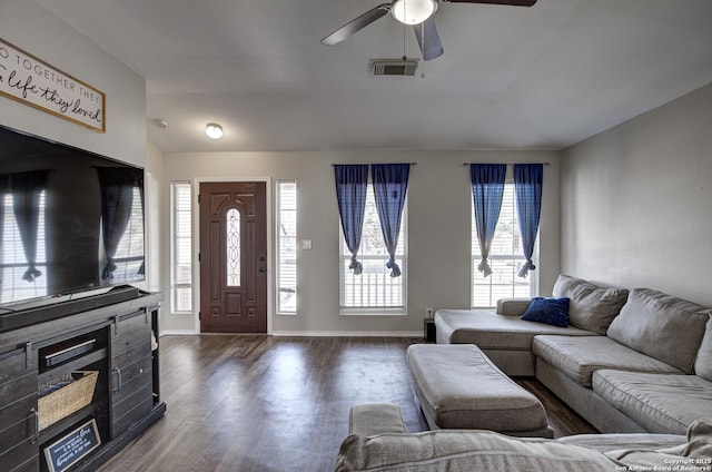 living room with lofted ceiling, dark wood-type flooring, visible vents, and baseboards