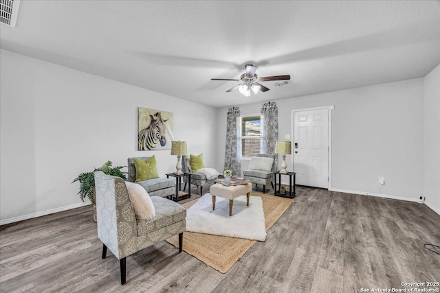 sitting room featuring wood finished floors, visible vents, and baseboards