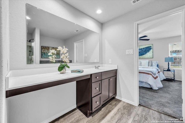 bathroom with ensuite bathroom, ceiling fan, vanity, wood finished floors, and baseboards