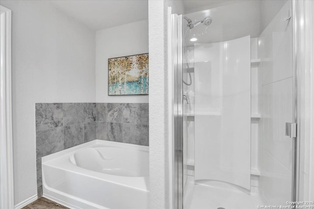 bathroom with a stall shower and a garden tub