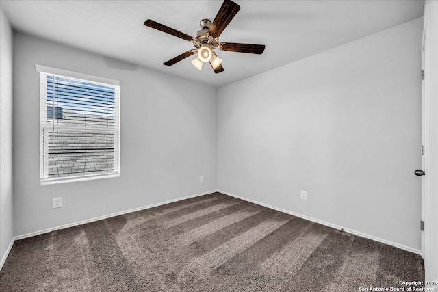 carpeted empty room featuring ceiling fan and baseboards