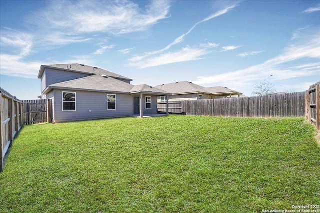 back of property featuring a fenced backyard and a lawn