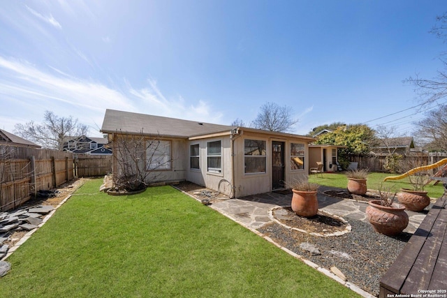 rear view of house featuring a patio area, a fenced backyard, a yard, and a fire pit