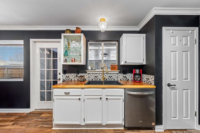 kitchen featuring wood finished floors, a sink, white cabinetry, ornamental molding, and stainless steel dishwasher