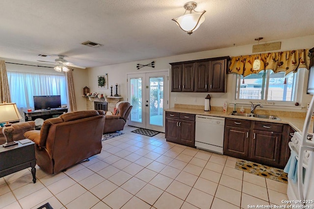 kitchen featuring open floor plan, white dishwasher, light countertops, french doors, and a sink