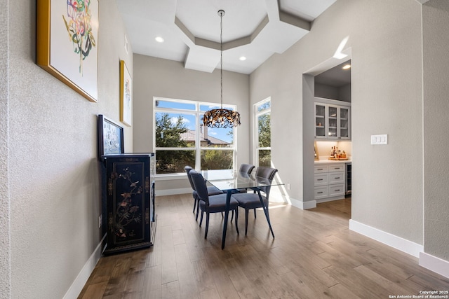 dining area with recessed lighting, a textured wall, wood finished floors, beverage cooler, and baseboards