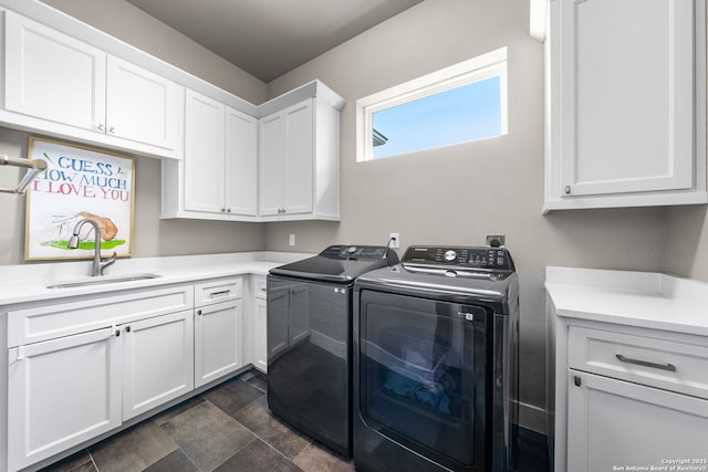 washroom with stone finish floor, a sink, cabinet space, and washer and dryer